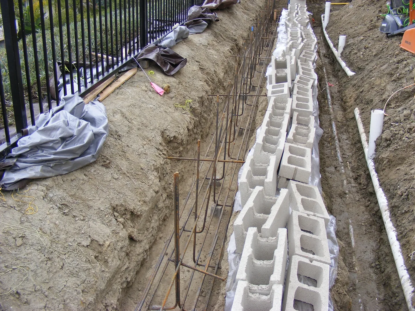 A trench with concrete blocks and steel rods.